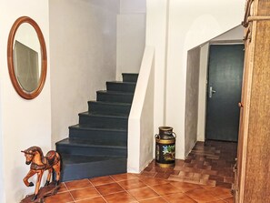 A staircase with a wooden handrail, a decorative horse sculpture, and a door at the bottom.