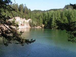 Un lac paisible, bordé d’une forêt dense et de falaises rocheuses.