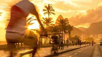 A sunset view with palm trees and a road.