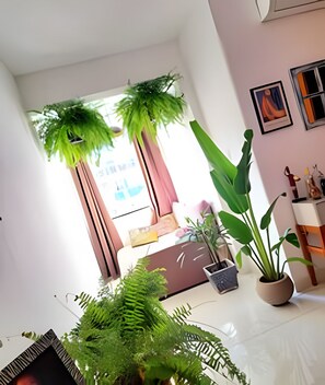 Een moderne woonkamer met een bank, een salontafel en een grote kamerplant.