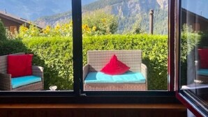 Ein Zimmer mit großem Fenster und Blick auf die Berge.