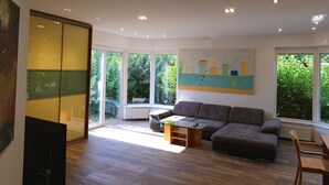 A modern living room with a sectional sofa, a coffee table, and a painting on the wall. - Pool-Wellness JOSKA by Interhome (Mladá Boleslav)