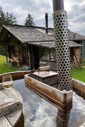 A rustic cabin with a wooden deck and a hot tub. - Kirschbaumhütte by Interhome (Gündlischwand)