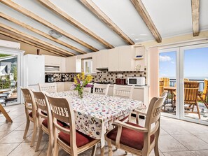 A dining area with a table, chairs, and a view of the sea. - Vacation home Elisa by Interhome (Plomin)