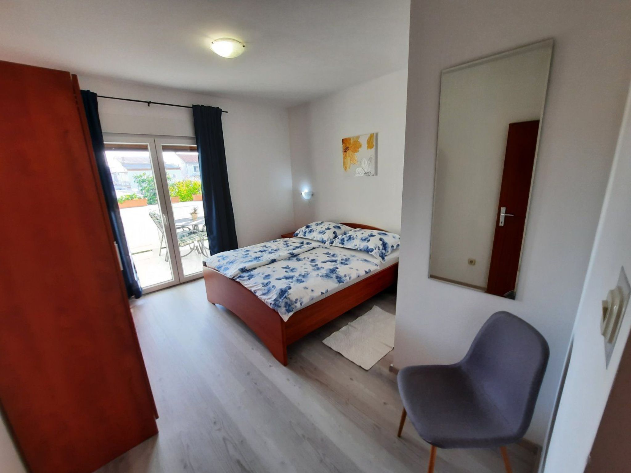 Una camera da letto con un letto, una sedia, una porta e una finestra.