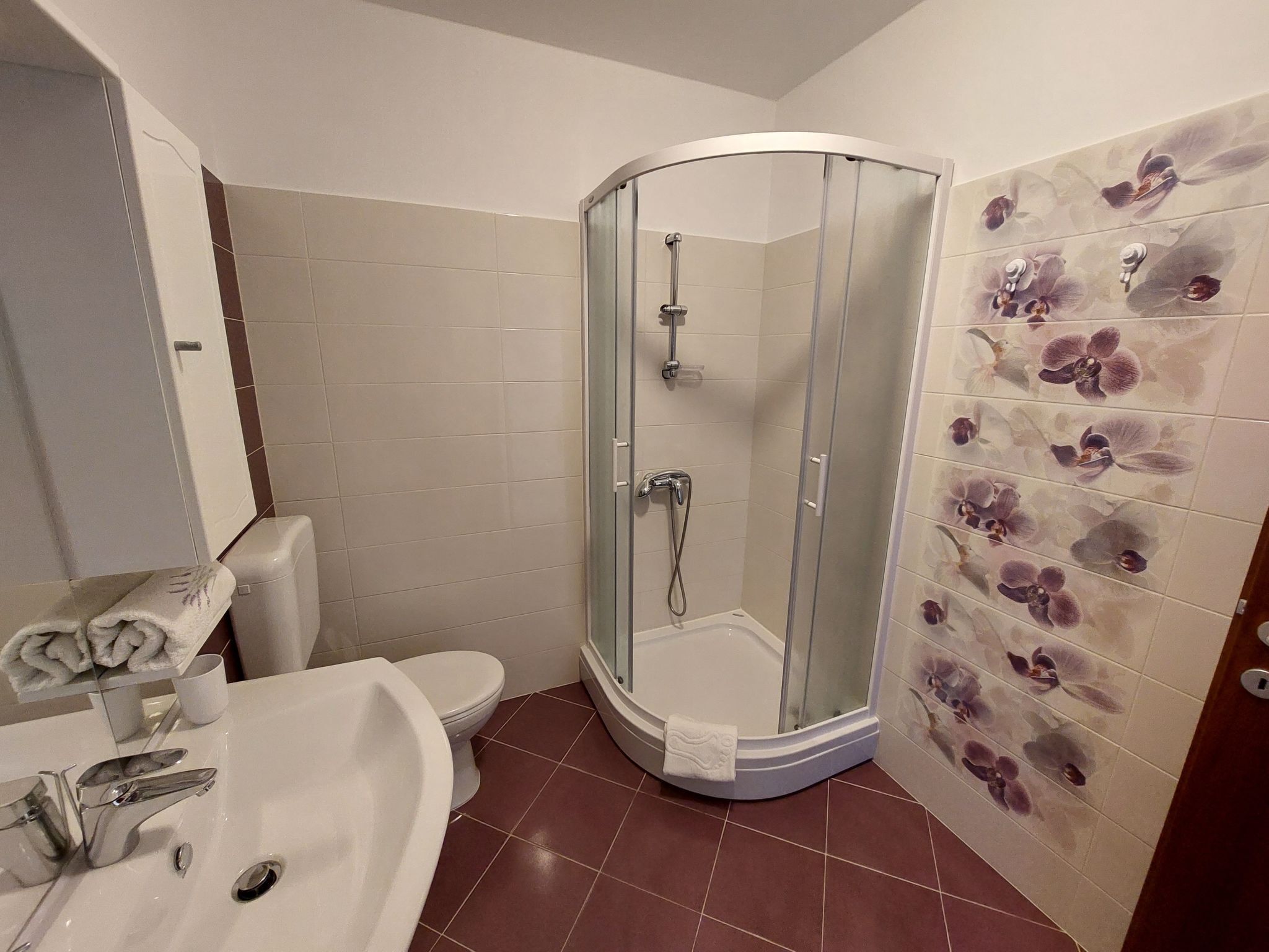 Un baño con ducha de vidrio, inodoro blanco y bañera con una toalla.