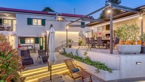 A modern outdoor patio area with seating, a covered dining area, and a staircase leading to the upper floor. - Villa LETICIJA - Luxusvilla mit beheiztem Pool, Sauna, Fitness & Grillplatz in by Interhome (Hreljin)