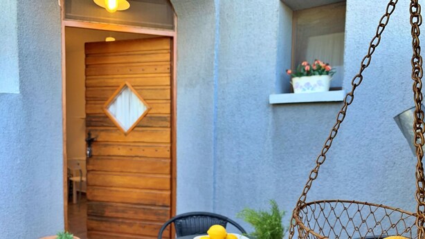An outdoor seating area with a table, chairs, and a hanging chair with cushions. - Studio Savic by Interhome (Krk/Šilo)