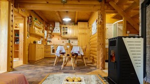 A cozy log cabin interior with wooden furniture, a dining table, and a black refrigerator. - IDEAL FÜR FAMILIEN, PAARE UND NATURLIEBHABER by Interhome (Lokve)