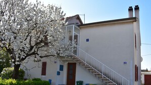 A two-story building with a staircase leading to the upper floor. There are trash bins and a small shed near the entrance. - Gemütliche Wohnung in Meeresnähe by Interhome (Fažana)