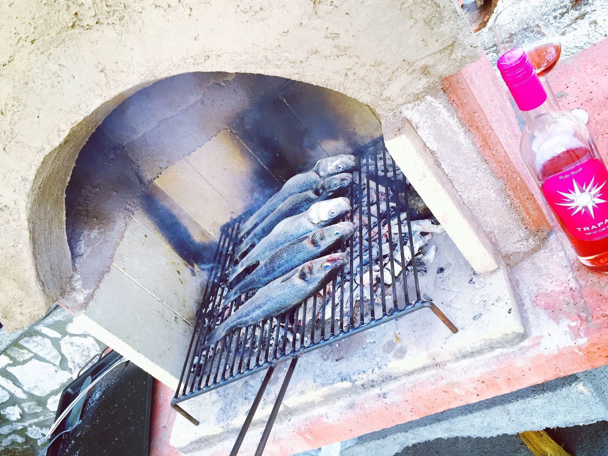 Een barbecue met vis die er op ligt te bakken.