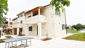 A stone building with a balcony, a table tennis table, and a small garden area. - "Villa Ulika" mit eigenem Pool by Interhome (Rovinj/Kanfanar)