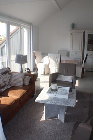 A living room with a brown sofa, a white armchair, a marble coffee table, and a lamp. - Ruhig gelegenes Ferienhaus in De Haan by Interhome (De Haan)