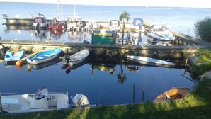 Un port esportiu amb diverses embarcacions amarrades, incloent un petit llanç motor acompanyat d'un motor fueraborda Johnson.