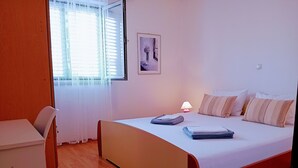 A bedroom with a bed, bedside table, lamp, and a window with curtains. - Anwesen "Krasno" mit Terrasse by Interhome (Rovinj)