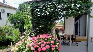 A garden with pink hydrangeas and a pergola covered in ivy. - Anwesen "Krasno" mit Terrasse by Interhome (Rovinj)
