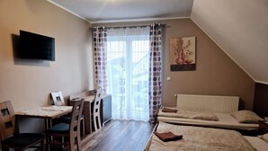 A small, cozy room with a wooden desk, a bed, and a TV mounted on the wall. - mit Wasserblick by Interhome (Wisełka)