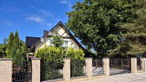 A two-story house with a stone facade, a gated entrance, and a well-maintained garden. - mit Wasserblick by Interhome (Wisełka)