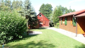 A red wooden cabin with a small porch and a grassy yard. - Glücksurlaub mit Hund am See by Interhome (Rózansko)