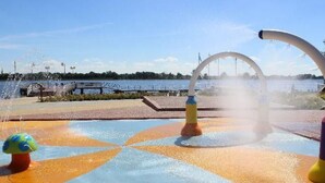 Un espace de jeux aquatiques doté de plusieurs jets d’eau et d’une fontaine en forme de globe.