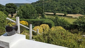 A rural landscape with a white fence, a potted plant, and yellow flowers. - Velvet Cottage by Interhome (Pentrefelin)
