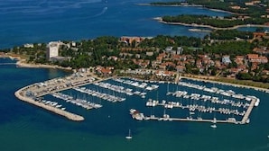 An aerial view of a coastal marina with multiple docks and boats, surrounded by residential buildings and greenery. - Villa Deni by Interhome (Buje)