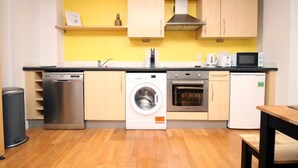 Eine kleine Küche mit Waschmaschine, Backofen und Mikrowelle.