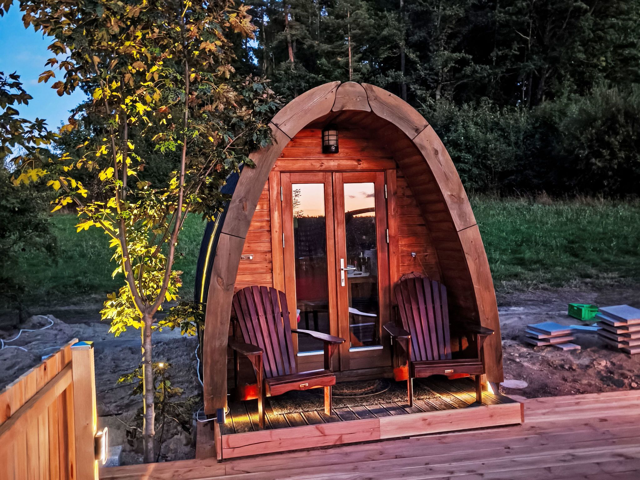 Una cabaña de madera con dos sillas y una puerta.