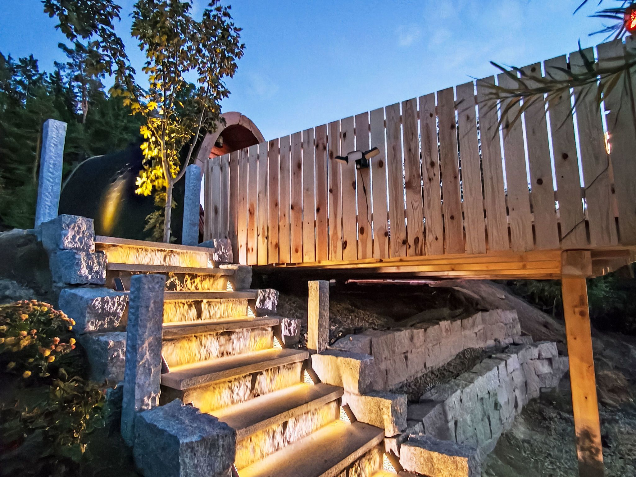 Une terrasse en bois avec des marches en pierre menant à celle-ci.