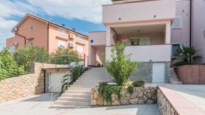 Un immeuble d’appartements moderne avec un escalier en pierre menant à une entrée abritée.