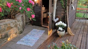 Eine Holzhütte mit Steinwand und einer Holzterrasse.