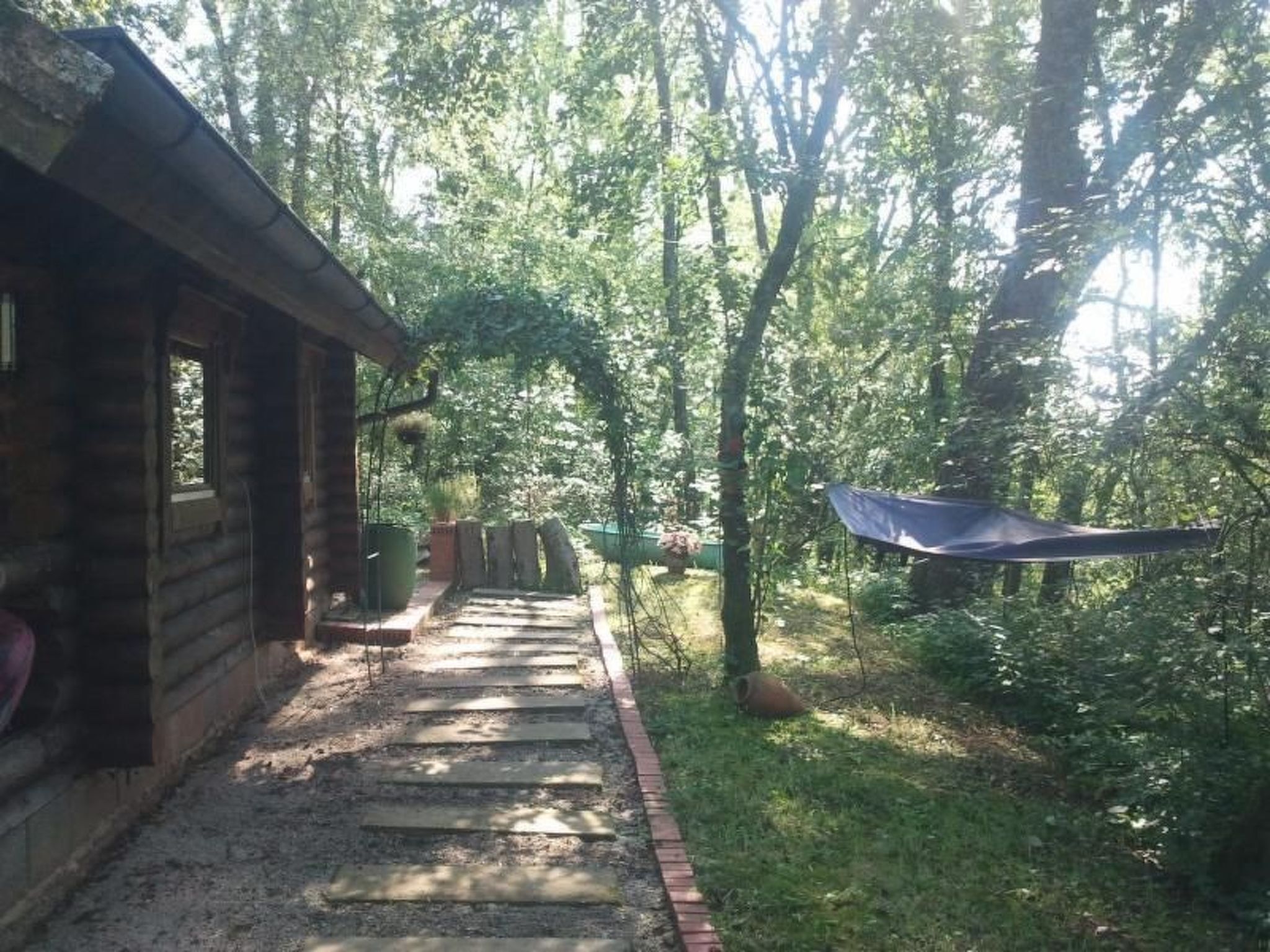 A wooden cabin with a stone pathway leading to a covered area.