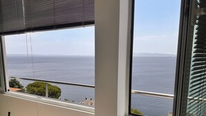 A room with a large window overlooking a body of water and distant land. - Wohnung Fiorino Rijeka, Kvarner Bucht by Interhome (Rijeka)