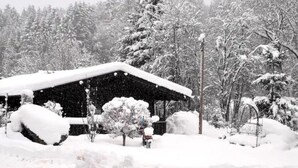 Ein mit Schnee bedecktes Holzhäuschen mit einem verschneiten Dach.