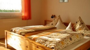A bedroom with two single beds, a window with curtains, a radiator, and a small picture on the wall. - Apartment Gottal by Interhome (Neuschönau)