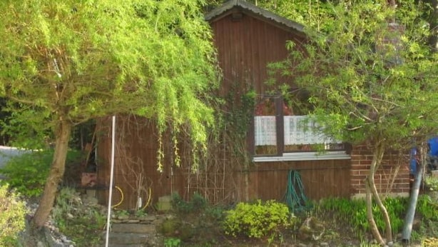 A rustic wooden cabin surrounded by lush greenery and a small stream. - Apartment Gottal by Interhome (Neuschönau)