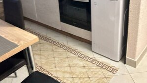 A compact kitchen with a microwave, oven, and refrigerator. There is a wooden countertop and a patterned rug on the floor. - Villa Hanka App.Piccolo, Balkon bis 3 Pers. EG by Interhome (Umag)