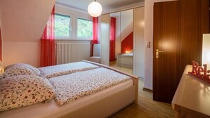 Un dormitorio con una cama, un radiador y una ventana.