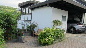 A modern house with a garage, a bench, and potted plants. - Fe.Wo.Renate Ebach by Interhome (Alf)