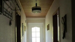 A hallway with a tiled floor, a wooden ceiling, and a door at the end. - Fe.Wo.Renate Ebach by Interhome (Alf)