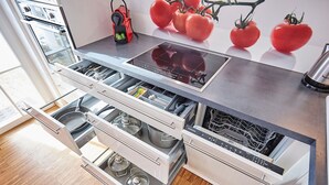 Eine moderne Küche mit integrierten Geräten, darunter ein Backofen, eine Spülmaschine und ein Kochfeld.