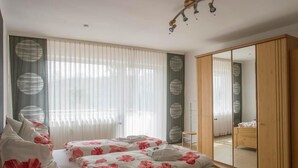 Un dormitorio con dos camas, un espejo grande y un armario.