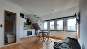 Um apartamento moderno com cozinha, sala de jantar e uma janela grande.
