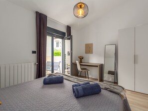 Ein modernes Schlafzimmer mit einem großen Bett, einem Schreibtisch und einem Sessel.