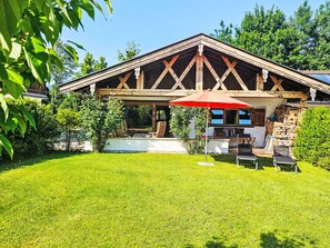 A rustic wooden building with a covered patio area, outdoor seating, and a well-maintained lawn. - Gottschlicht by Interhome (Rottach-Egern)