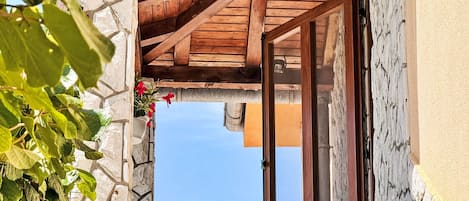 Un edificio de piedra con una escalera de madera que conduce a una puerta.