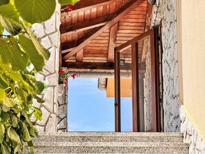 A stone building with a wooden staircase leading to a door. - Apartment Nevenka by Interhome (Krk/Čižići)