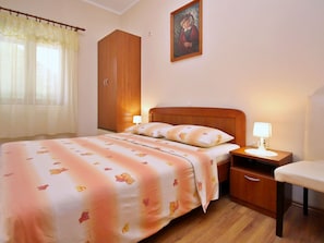 Ein Schlafzimmer mit Bett, Nachttisch, Schrank und einer Kommode.