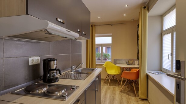 A compact kitchen with modern appliances, a dining area with two chairs, and a window with blinds. - Gäuls-Stadl by Interhome (Marktheidenfeld)
