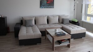 A modern living room with a sectional sofa, a coffee table, and a bookshelf. - Wunderschön Wohnen in Weinheim by Interhome (Weinheim)